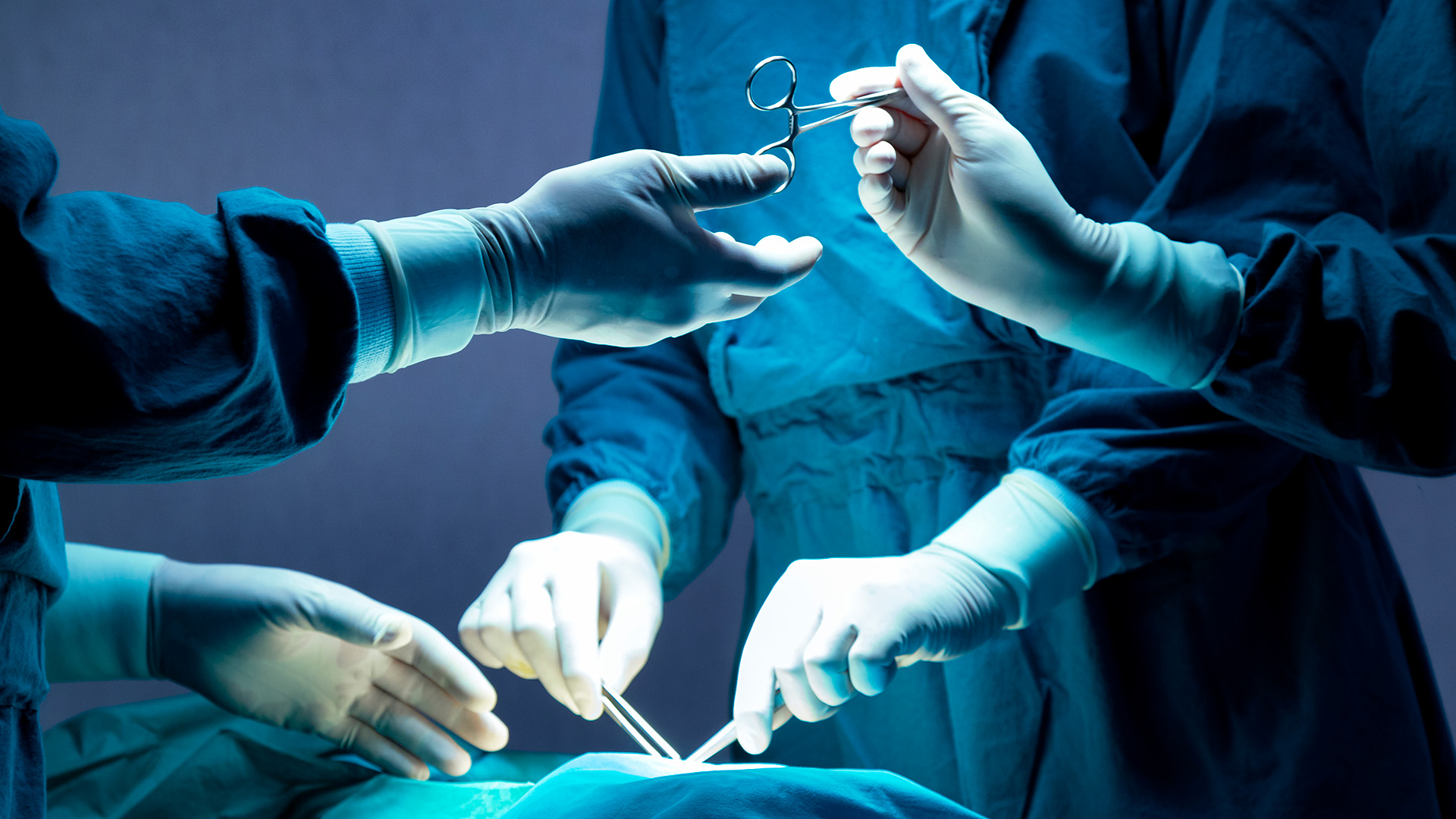 Operationstechnischer Assistent reicht das OP-Besteck während einer Operation