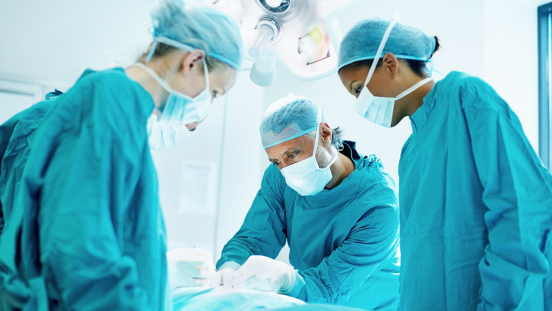 Drei Fachkrankenpfleger während einer Operation