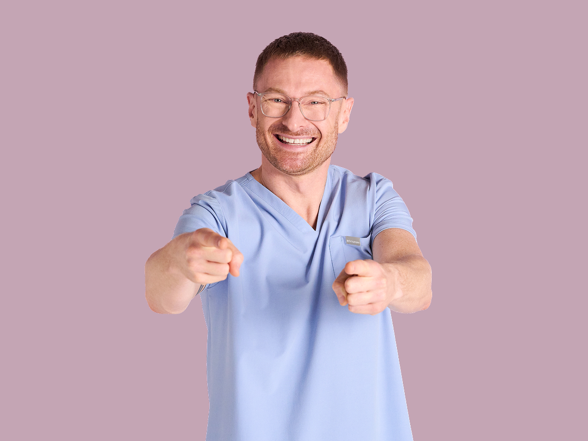 Pflegefachkraft zeigt mit den Fingern nach vorne Pflegefachkraft zeigt mit den Fingern nach vorne