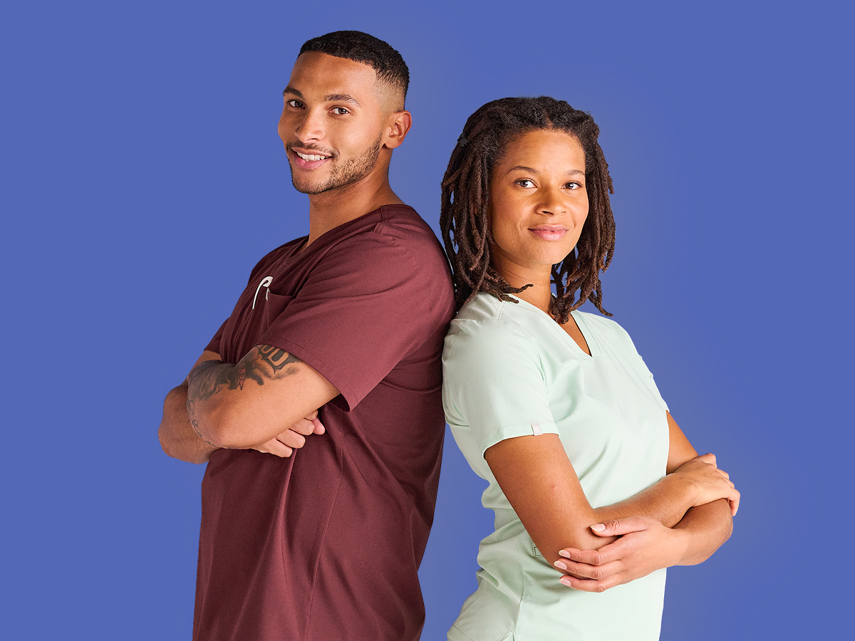 Zwei Pflegekräfte stehen Rücken an Rücken